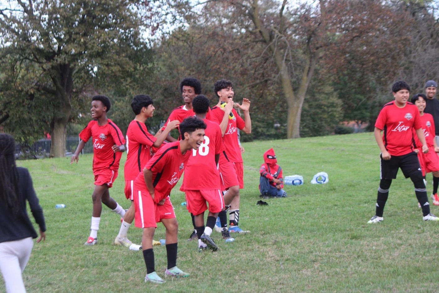 Young players and coaches celebrate together after a game